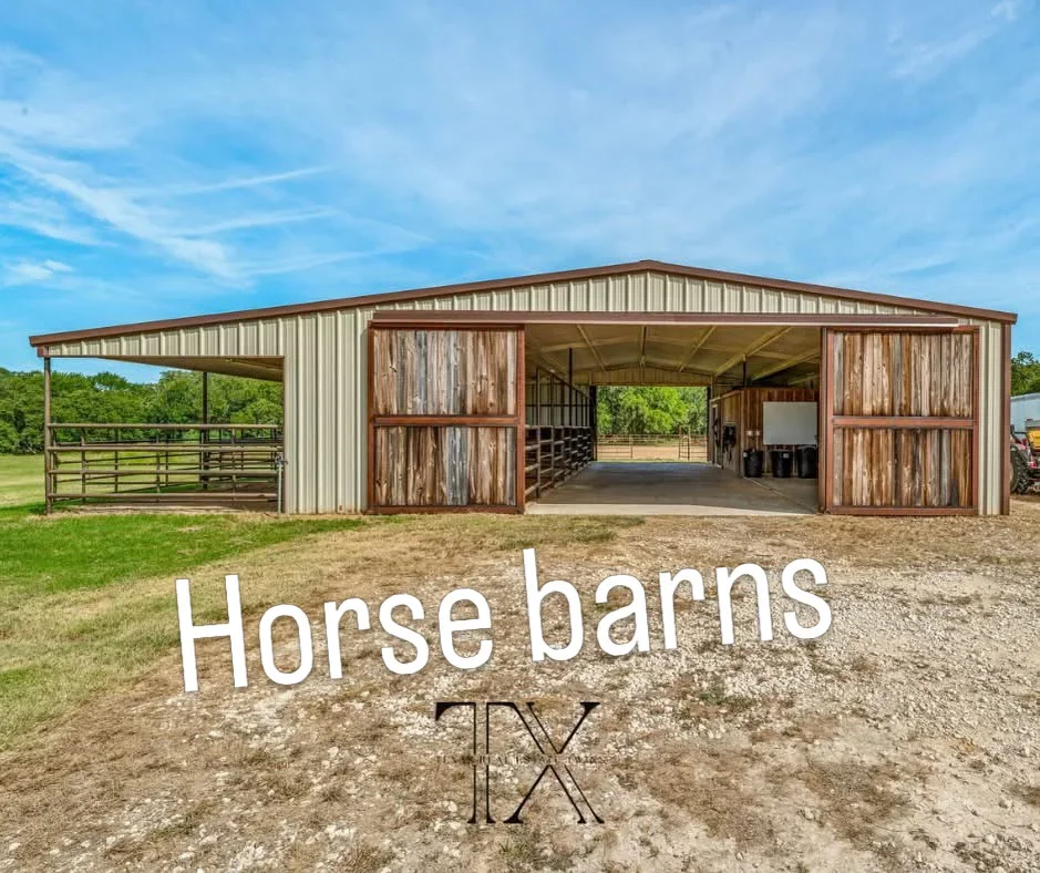 Metal-frame horse barn with corrugated steel siding, wooden doors, and covered shelter area